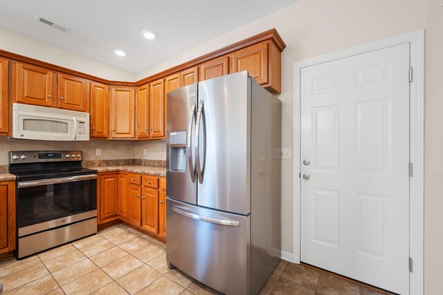 6239 Jacq Ct Unit 57, Hixson, TN 37343 - kitchen with stainless steel appliances, brown cabinetry, light tile patterned floors, light stone countertops, and recessed lighting