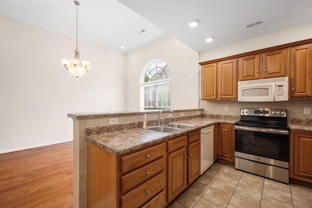 6239 Jacq Ct Unit 57, Hixson, TN 37343 - kitchen with white appliances, a peninsula, a chandelier, brown cabinets, and hanging light fixtures
