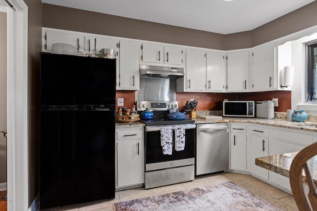 1008 Panorama Dr, Chattanooga, TN 37421 - kitchen with appliances with stainless steel finishes, under cabinet range hood, white cabinetry, light tile patterned flooring, and light stone counters