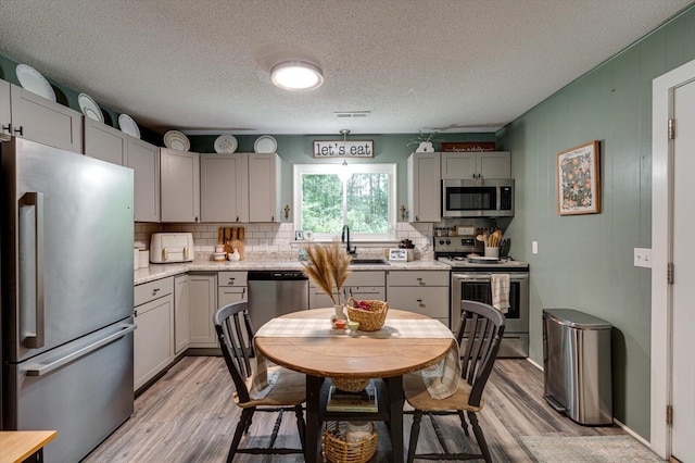 308 Pledger Pkwy, Lafayette, GA 30728 - kitchen with appliances with stainless steel finishes, gray cabinetry, light wood-style flooring, and a textured ceiling