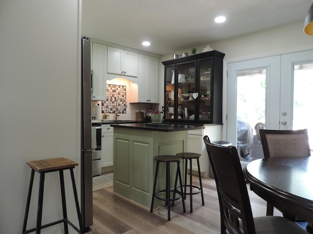 87 Lawrence Dr, Ringgold, GA 30736 - bar area with light wood-style floors, decorative backsplash, recessed lighting, and french doors