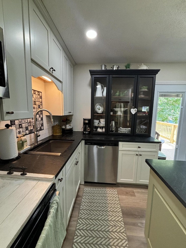 87 Lawrence Dr, Ringgold, GA 30736 - kitchen with stainless steel dishwasher, wood finished floors, a textured ceiling, decorative backsplash, and dark countertops
