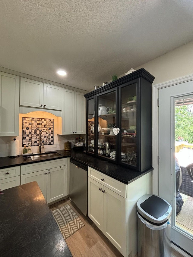 87 Lawrence Dr, Ringgold, GA 30736 - kitchen featuring stainless steel dishwasher, wood finished floors, a textured ceiling, tasteful backsplash, and dark countertops