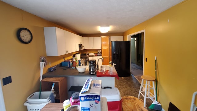 214 E Rhea Ave, Spring City, TN 37381 - kitchen with black refrigerator with ice dispenser, dark countertops, a peninsula, and exhaust hood