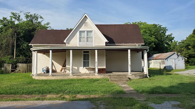 214 E Rhea Ave, Spring City, TN 37381 - view of front of house featuring covered porch, a front lawn, and a shed