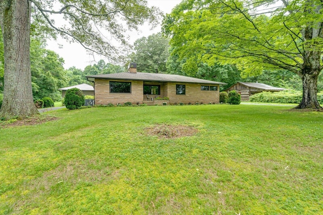395 Robinson Ln, Decatur, TN 37322 - ranch-style home featuring a chimney, a front yard, and brick siding