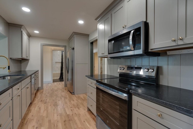 395 Robinson Ln, Decatur, TN 37322 - kitchen featuring appliances with stainless steel finishes, light wood-style flooring, gray cabinets, recessed lighting, and dark stone countertops