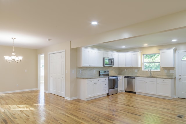 6102 Vance Rd, Chattanooga, TN 37421 - kitchen with appliances with stainless steel finishes, a chandelier, backsplash, light wood finished floors, and recessed lighting