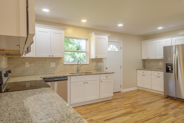6102 Vance Rd, Chattanooga, TN 37421 - kitchen with stainless steel appliances, white cabinetry, light wood-style floors, decorative backsplash, and light stone countertops