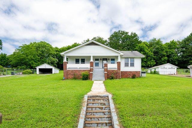 3313 Harrison Pike, Chattanooga, TN 37416 - bungalow-style house featuring a front yard, covered porch, a detached garage, and an outbuilding