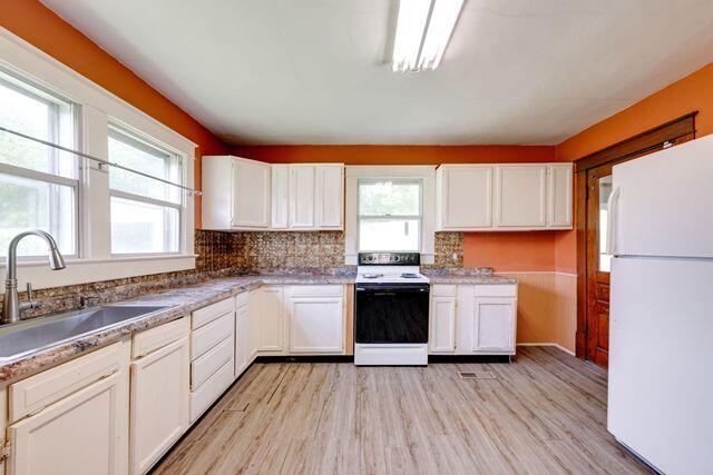 3313 Harrison Pike, Chattanooga, TN 37416 - kitchen with white appliances, white cabinetry, light wood-type flooring, and tasteful backsplash