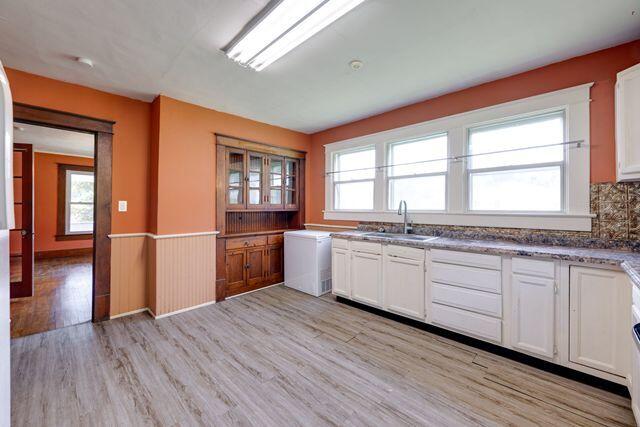3313 Harrison Pike, Chattanooga, TN 37416 - kitchen with light wood-type flooring, wainscoting, white cabinets, and healthy amount of natural light