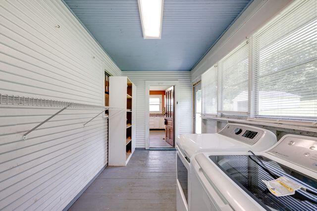3313 Harrison Pike, Chattanooga, TN 37416 - laundry area with washing machine and clothes dryer, wood finished floors, and wood walls