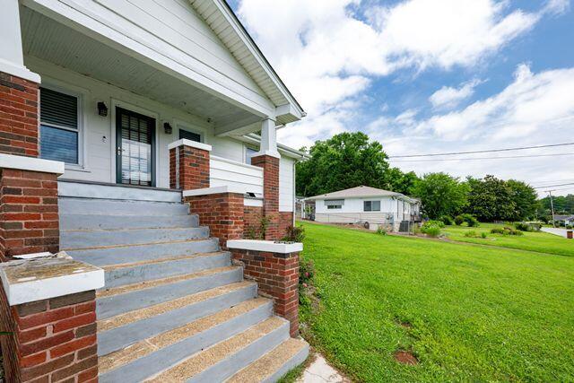 3313 Harrison Pike, Chattanooga, TN 37416 - entrance to property with covered porch, a yard, and brick siding