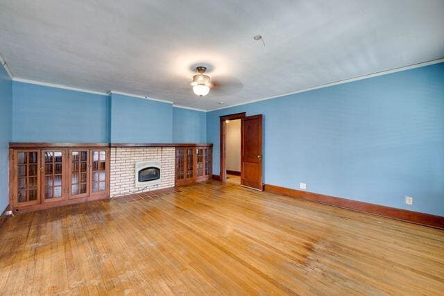 3313 Harrison Pike, Chattanooga, TN 37416 - unfurnished living room featuring light wood-style flooring, ornamental molding, a brick fireplace, and ceiling fan