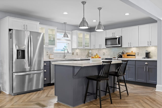 7622 Nadick Ln, Hixson, TN 37343 - kitchen with appliances with stainless steel finishes, glass insert cabinets, a kitchen bar, white cabinets, and recessed lighting