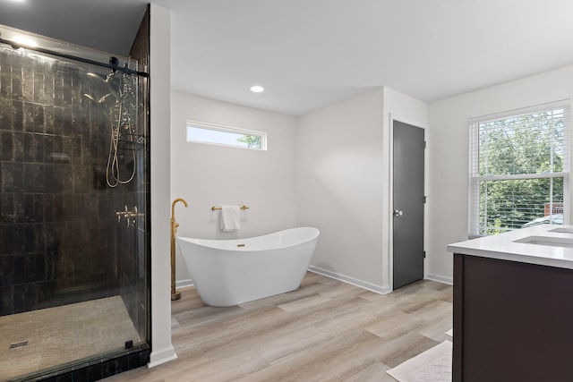 7622 Nadick Ln, Hixson, TN 37343 - bathroom featuring a shower stall, a freestanding tub, vanity, wood finished floors, and recessed lighting