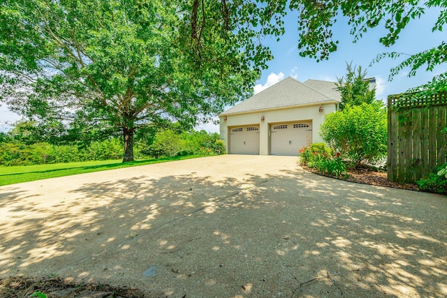 11216 Ooltewah Georgetown Rd, Georgetown, TN 37336 - view of side of home with driveway, stucco siding, a garage, and a shingled roof