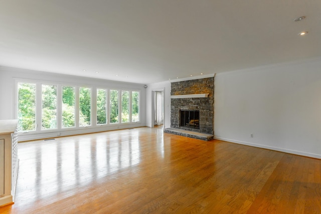 11216 Ooltewah Georgetown Rd, Georgetown, TN 37336 - unfurnished living room featuring light wood-type flooring, ornamental molding, a stone fireplace, and recessed lighting