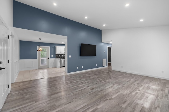 651 Howard Leonard Rd, Ringgold, GA 30736 - unfurnished living room with light wood finished floors, recessed lighting, lofted ceiling, wainscoting, and a chandelier