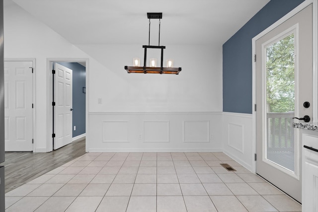 651 Howard Leonard Rd, Ringgold, GA 30736 - unfurnished dining area with a chandelier, a wainscoted wall, light tile patterned floors, and a decorative wall