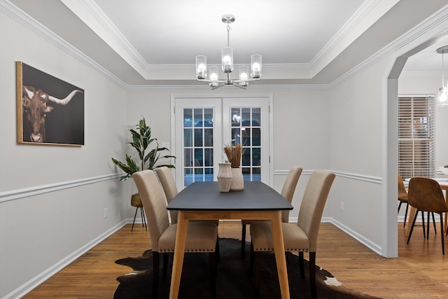8512 Creek Stone Dr, Chattanooga, TN 37421 - dining room featuring a chandelier, light wood-style flooring, a raised ceiling, crown molding, and arched walkways