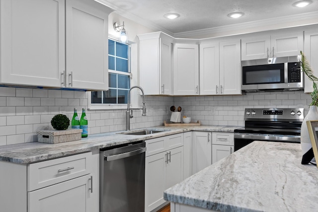 8512 Creek Stone Dr, Chattanooga, TN 37421 - kitchen with appliances with stainless steel finishes, crown molding, white cabinets, light stone countertops, and backsplash