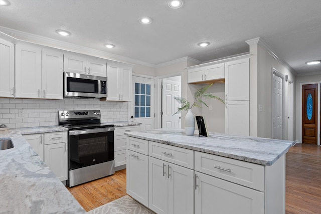8512 Creek Stone Dr, Chattanooga, TN 37421 - kitchen with stainless steel appliances, ornamental molding, light wood finished floors, white cabinets, and recessed lighting