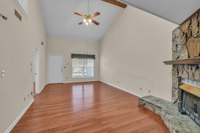 1259 Leaside Ln, Hixson, TN 37343 - unfurnished living room featuring high vaulted ceiling, a stone fireplace, ceiling fan, and wood finished floors