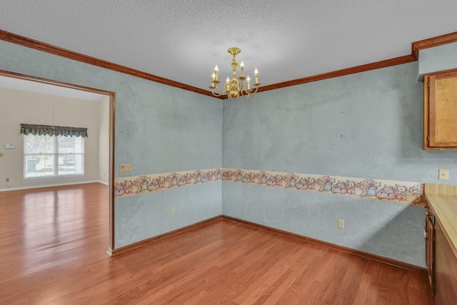 1259 Leaside Ln, Hixson, TN 37343 - unfurnished dining area featuring light wood finished floors, a chandelier, ornamental molding, and a textured ceiling