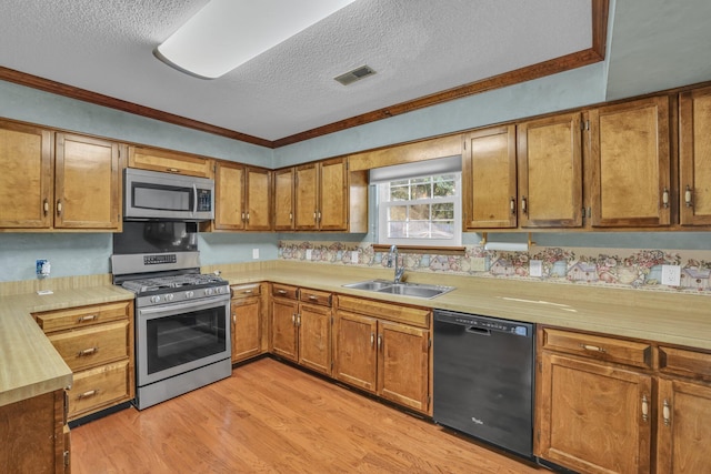 1259 Leaside Ln, Hixson, TN 37343 - kitchen with appliances with stainless steel finishes, brown cabinetry, a textured ceiling, light countertops, and crown molding