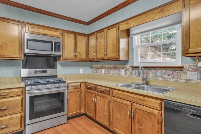 1259 Leaside Ln, Hixson, TN 37343 - kitchen with stainless steel appliances, light countertops, ornamental molding, light wood-style floors, and brown cabinets
