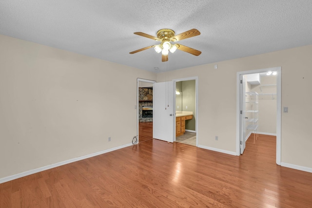 1259 Leaside Ln, Hixson, TN 37343 - unfurnished bedroom with a walk in closet, light wood finished floors, a closet, a textured ceiling, and ensuite bath