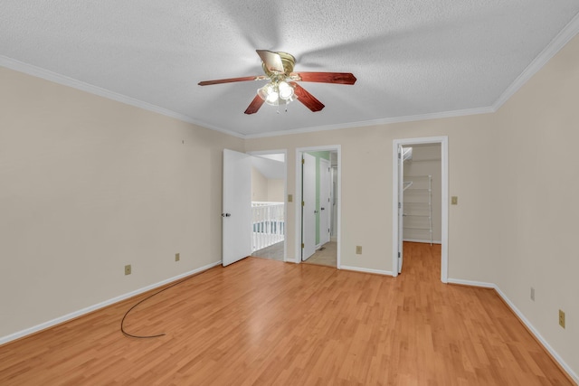 1259 Leaside Ln, Hixson, TN 37343 - unfurnished bedroom featuring light wood-style flooring, a textured ceiling, a walk in closet, ornamental molding, and ceiling fan