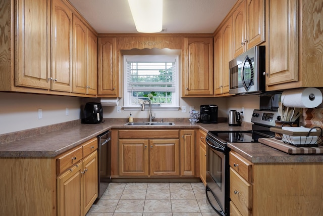 750 Windrush Loop, Chattanooga, TN 37421 - kitchen with stainless steel appliances, dark countertops, light tile patterned floors, and brown cabinetry