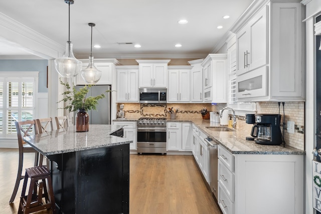 3528 Morning Dew Cv, Apison, TN 37302 - kitchen featuring appliances with stainless steel finishes, a breakfast bar, crown molding, light wood-style flooring, and white cabinetry
