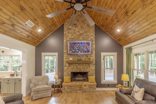 508 Chattanooga Rd, Cohutta, GA 30710 - living area with a wooden ceiling with exposed beams, a stone fireplace, a ceiling fan, light wood-style floors, and plenty of natural light