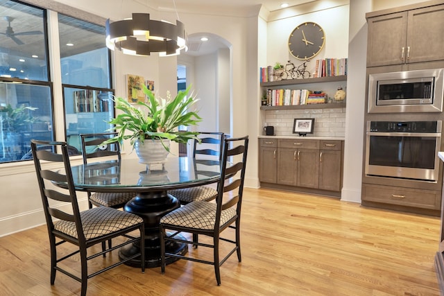 179 Rushing Water Trl, Rising Fawn, GA 30738 - dining area featuring light wood finished floors, arched walkways, a ceiling fan, and a chandelier