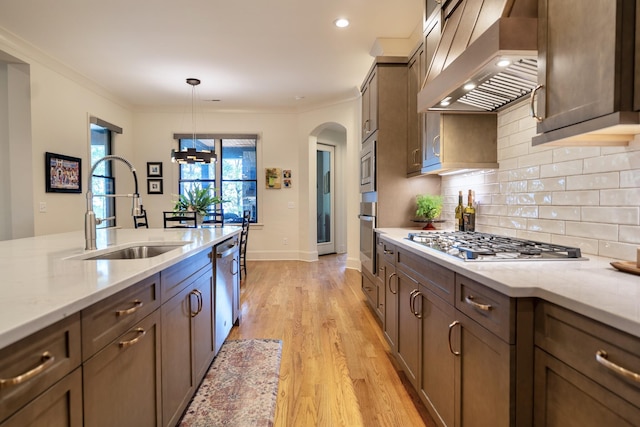179 Rushing Water Trl, Rising Fawn, GA 30738 - kitchen featuring ventilation hood, stainless steel appliances, arched walkways, backsplash, and light wood-style flooring