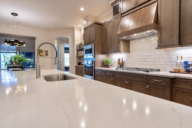179 Rushing Water Trl, Rising Fawn, GA 30738 - kitchen featuring wall chimney range hood, stainless steel appliances, arched walkways, decorative backsplash, and ornamental molding
