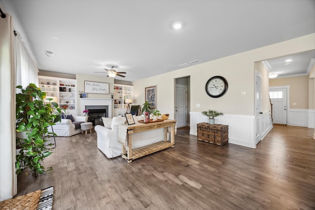 8517 Kensley Ln, Hixson, TN 37343 - living room with a ceiling fan, a fireplace, wood finished floors, a wainscoted wall, and crown molding