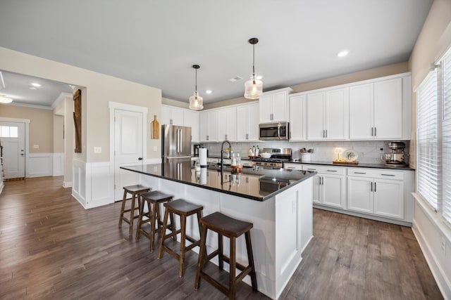 8517 Kensley Ln, Hixson, TN 37343 - kitchen featuring stainless steel appliances, dark countertops, plenty of natural light, a wainscoted wall, and a decorative wall