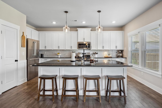 8517 Kensley Ln, Hixson, TN 37343 - kitchen with appliances with stainless steel finishes, backsplash, an island with sink, a breakfast bar area, and recessed lighting