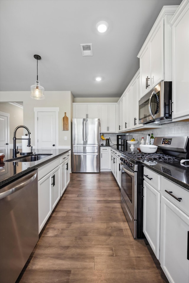 8517 Kensley Ln, Hixson, TN 37343 - kitchen with appliances with stainless steel finishes, white cabinetry, dark wood-style floors, pendant lighting, and backsplash