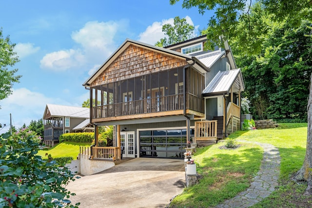 8223 Snow Hill Rd, Ooltewah, TN 37363 - rustic home featuring concrete driveway, a sunroom, a metal roof, an attached garage, and a front yard