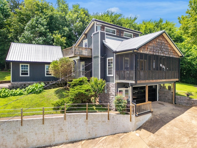 8223 Snow Hill Rd, Ooltewah, TN 37363 - rustic home featuring a sunroom, concrete driveway, a metal roof, a garage, and stone siding