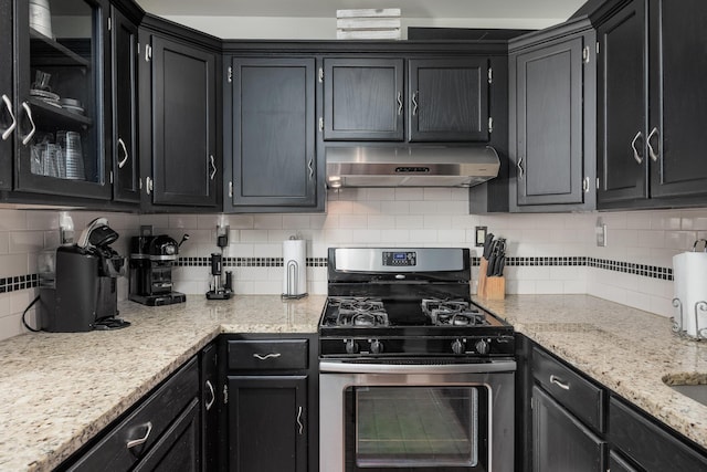 8223 Snow Hill Rd, Ooltewah, TN 37363 - kitchen with stainless steel gas range oven, under cabinet range hood, backsplash, and dark cabinets