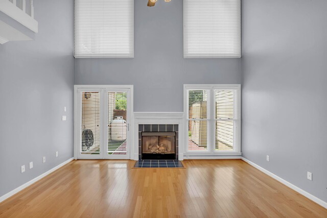 7414 Hamilton Run Dr, Chattanooga, TN 37421 - unfurnished living room with a high ceiling, a tile fireplace, and wood finished floors