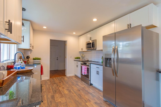 136 Cochran Dr NE, Dalton, GA 30721 - kitchen with appliances with stainless steel finishes, wood finished floors, white cabinetry, tasteful backsplash, and recessed lighting