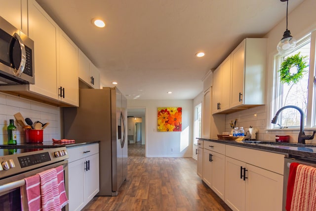 136 Cochran Dr NE, Dalton, GA 30721 - kitchen featuring appliances with stainless steel finishes, dark countertops, healthy amount of natural light, white cabinets, and recessed lighting